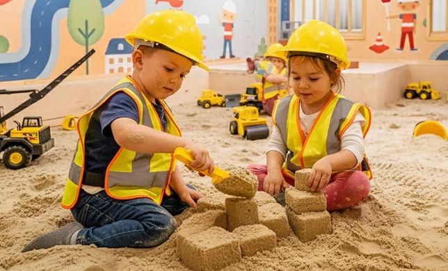 Children playing in the Digging Dreams sandbox with construction toys